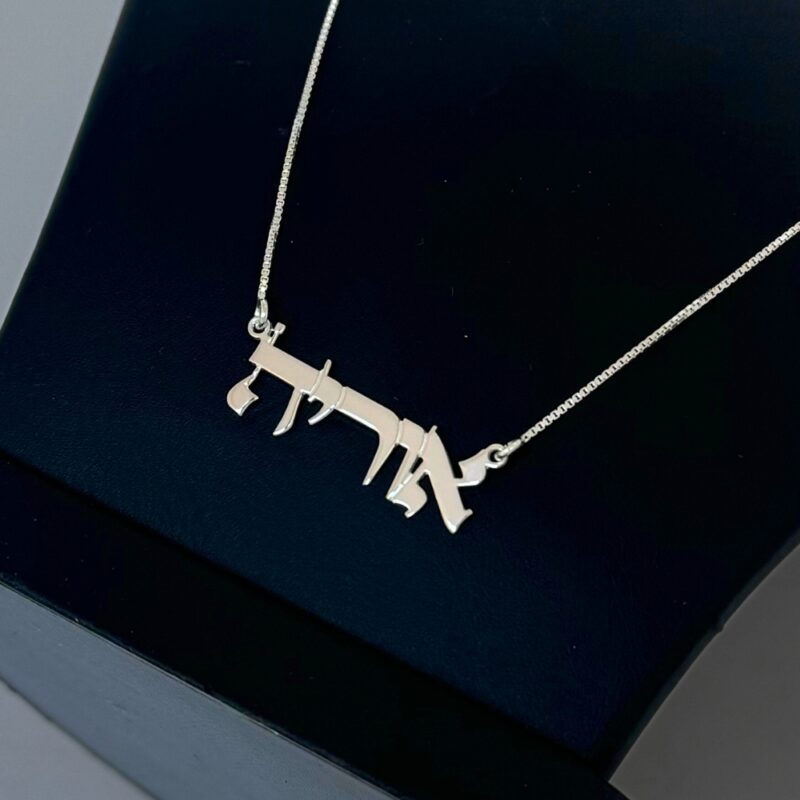 Close-up of 14K Solid Gold Hebrew Name Necklace against a dark backdrop