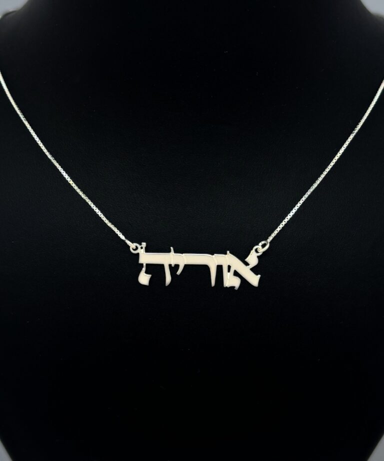 Jewelry piece displayed on black bust stand with soft lighting
