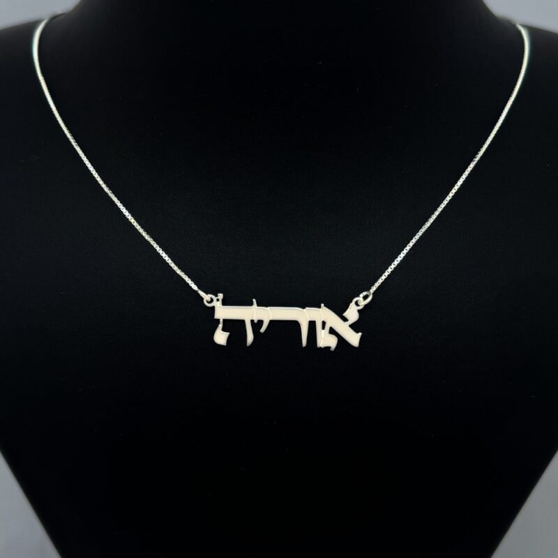 Jewelry piece displayed on black bust stand with soft lighting