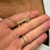 Personalized name pendant shown in close-up hand shot
