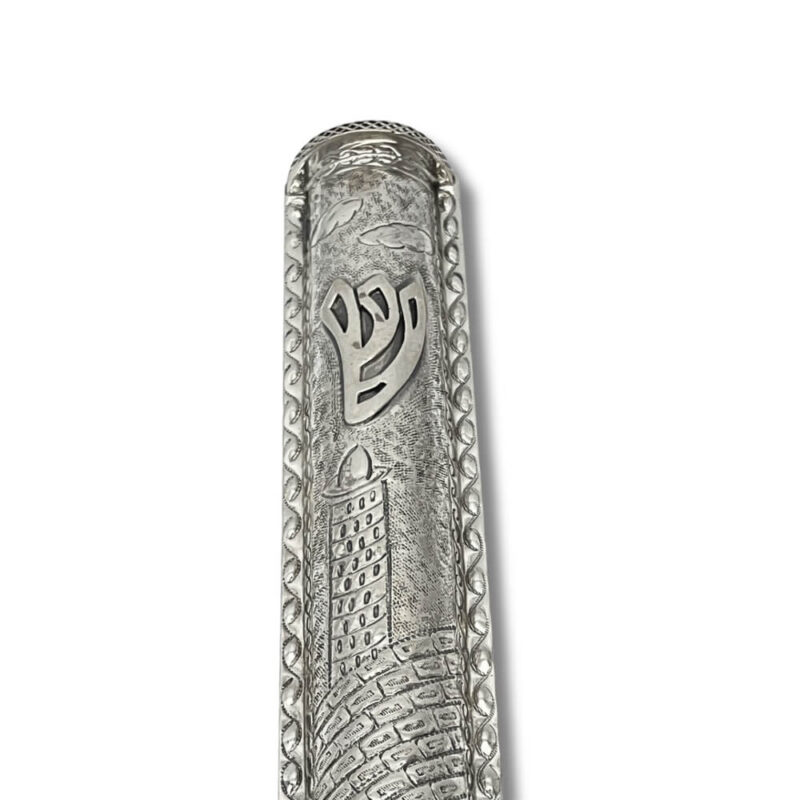 Close-up of raised Shin symbol on decorative silver mezuzah with Jerusalem motif
