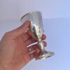 Hand holding a handcrafted Silver Kiddush Cup to show texture and size