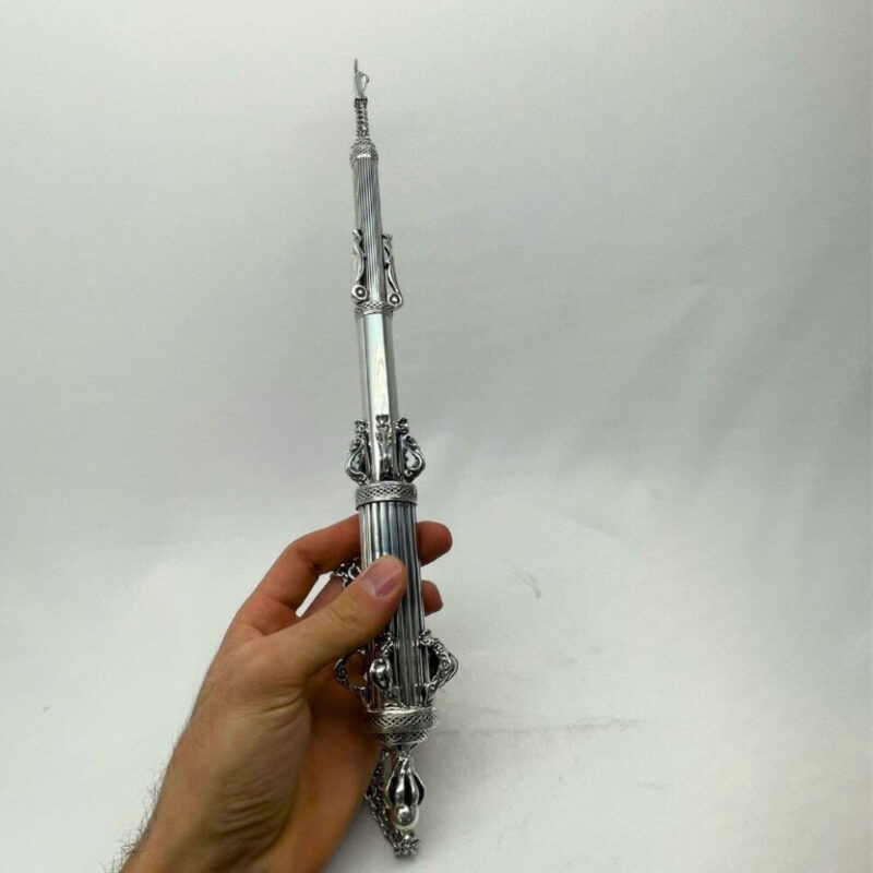 Hand holding a traditional Torah pointer for scale
