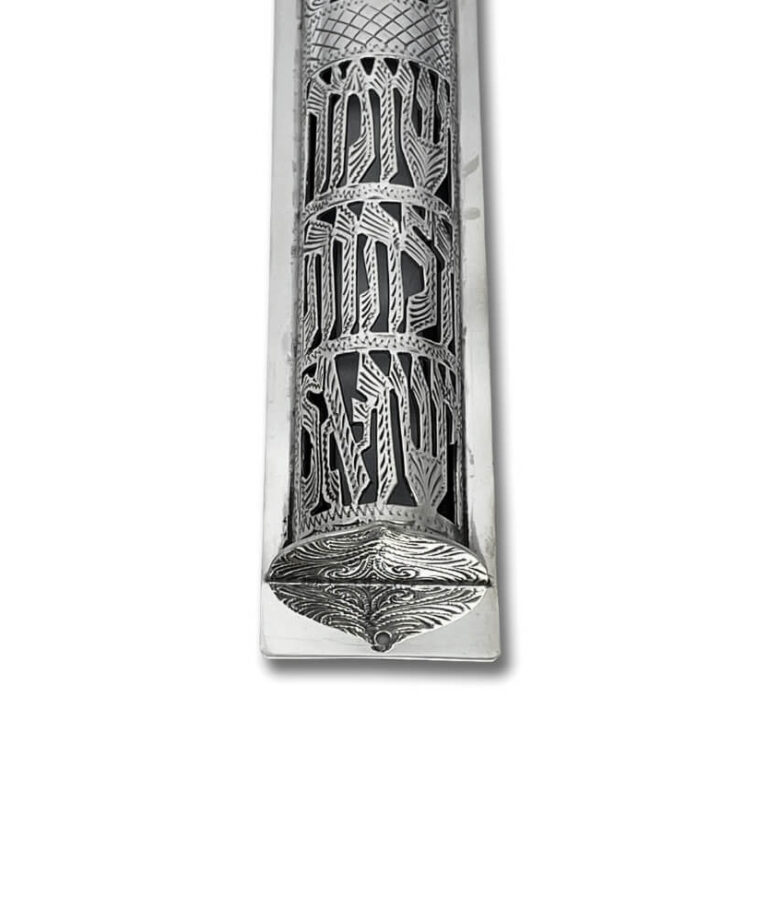 Close-up of engraved Hebrew letters and floral designs on the silver mezuzah