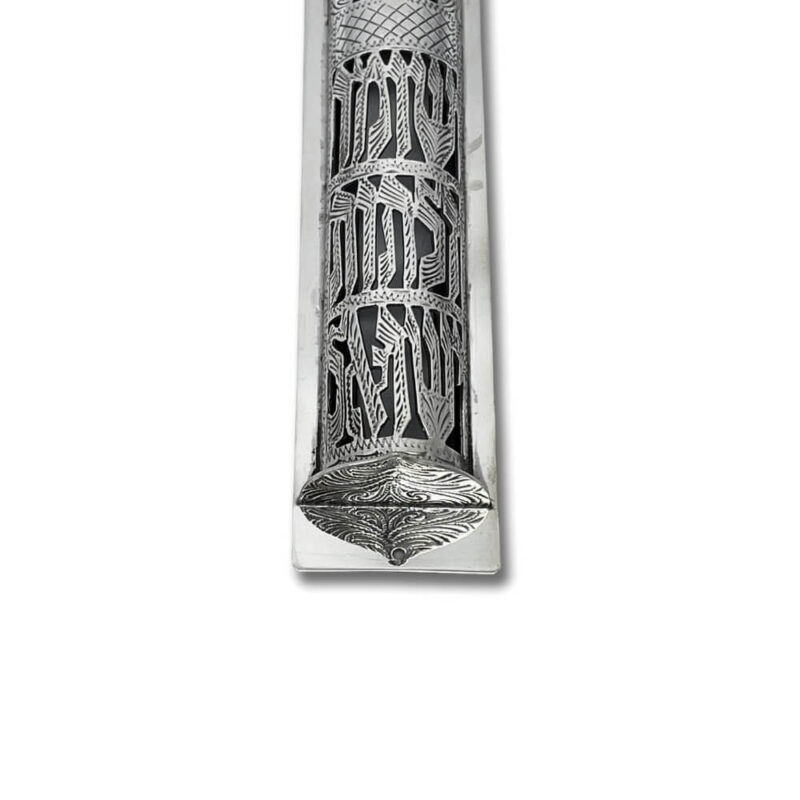 Close-up of engraved Hebrew letters and floral designs on the silver mezuzah