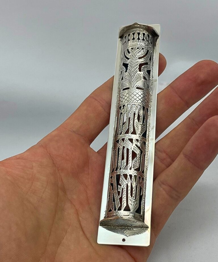 Sterling Silver Mezuzah Case held in hand, showcasing detailed filigree and Hebrew engraving
