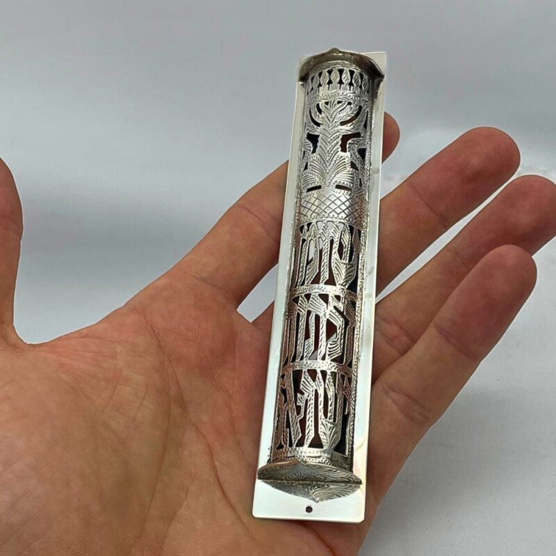 Sterling Silver Mezuzah Case held in hand, showcasing detailed filigree and Hebrew engraving