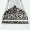 Detailed engraving on the decorative bottom of the mezuzah case in floral oriental style
