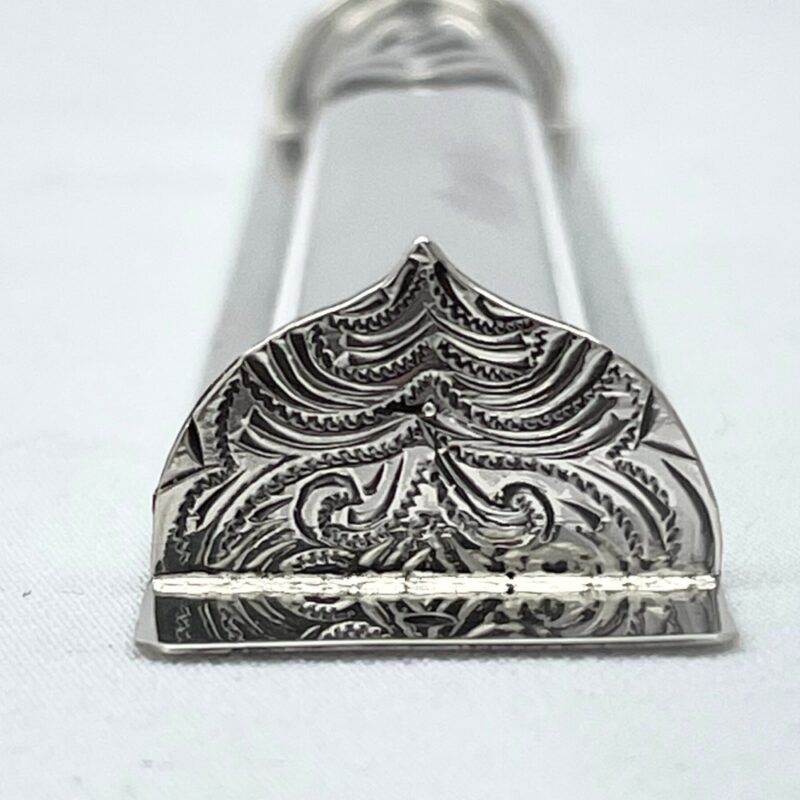 Detailed engraving on the decorative bottom of the mezuzah case in floral oriental style