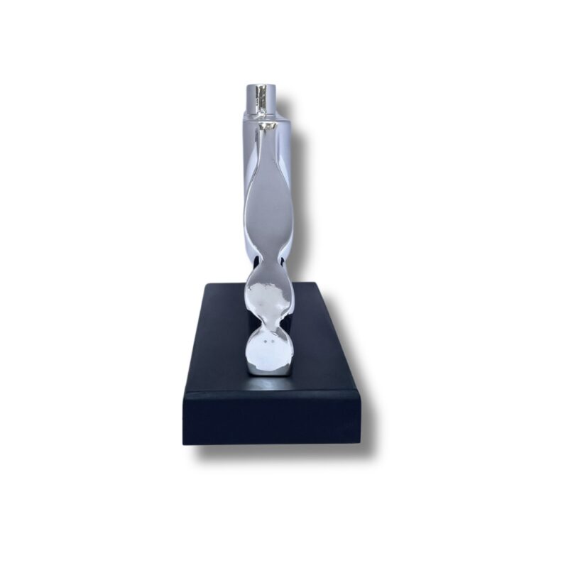 Side view of a modern silver Hanukkah candle holder on black wood base