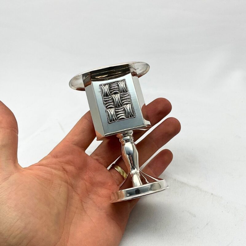 Hand holding silver Havdalah candle holder made in Jerusalem