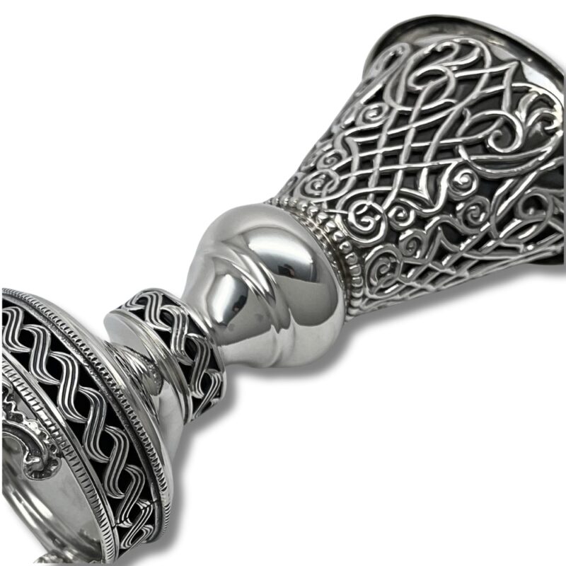 Close-up of the Havdalah Candle Holder’s mid-section, focusing on the smooth silver ball joint and the ornate wavy filigree patterns on the connected bands