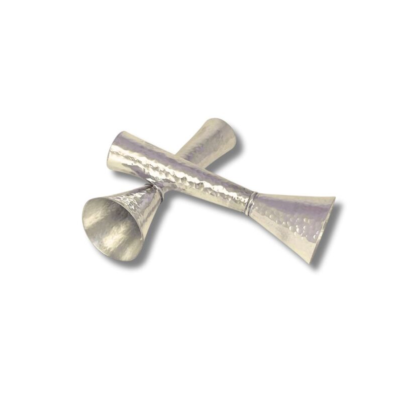 Angled view of silver hammered Shabbat candle holders crossed over each other