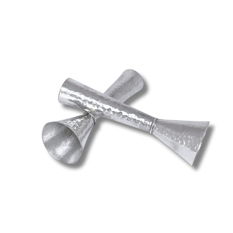 Angled view of silver hammered Shabbat candle holders crossed over each other