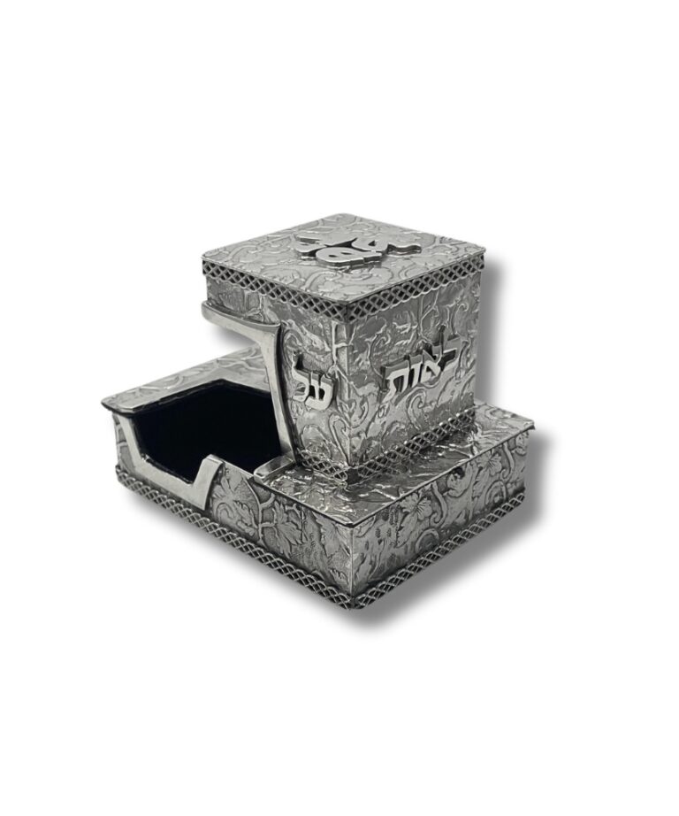 Top-down angle of silver tefillin box with bold “יד” engraving and ornate surface