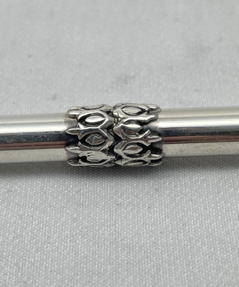 Close-up of decorative silver engravings on Torah pointer