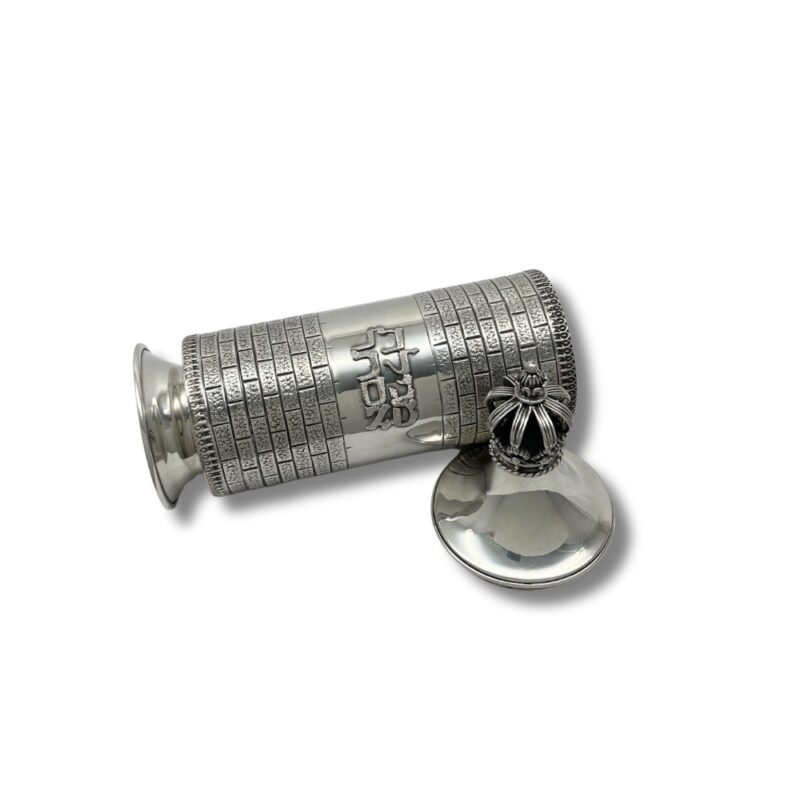 Decorative silver Megillah case lying open with detached crown lid beside it