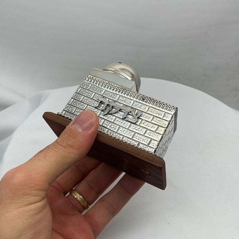 Hand holding a handcrafted Sterling Silver Tzedakah Box with wood base