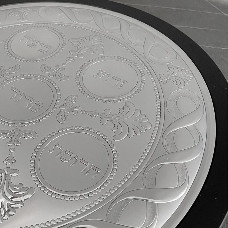 Close-up of the engraved Charoset, Z’roa and Beitzah sections with floral decorations on the Seder plate