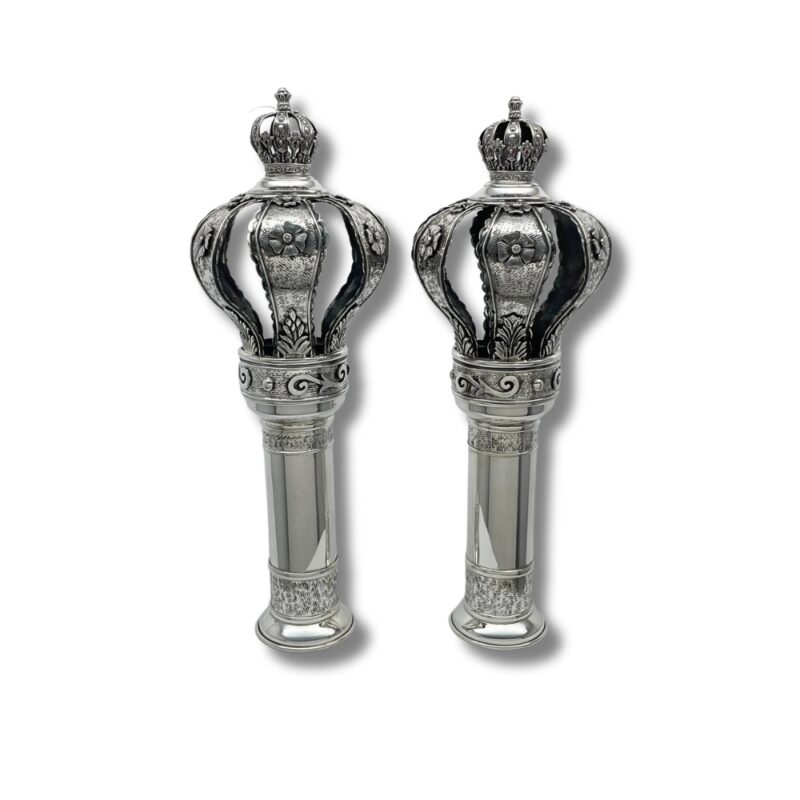 Angled view of 925 sterling silver Torah finials showing floral crowns with open sections and polished stems
