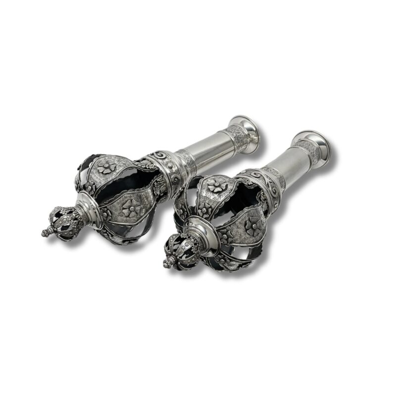 Side perspective of Torah finials highlighting the handcrafted flowers and textured silver crown structure