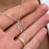 14K White Gold Chai outline pendant necklace held in hand