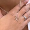 Jewish Chai necklace in white gold shown on hand with engagement ring