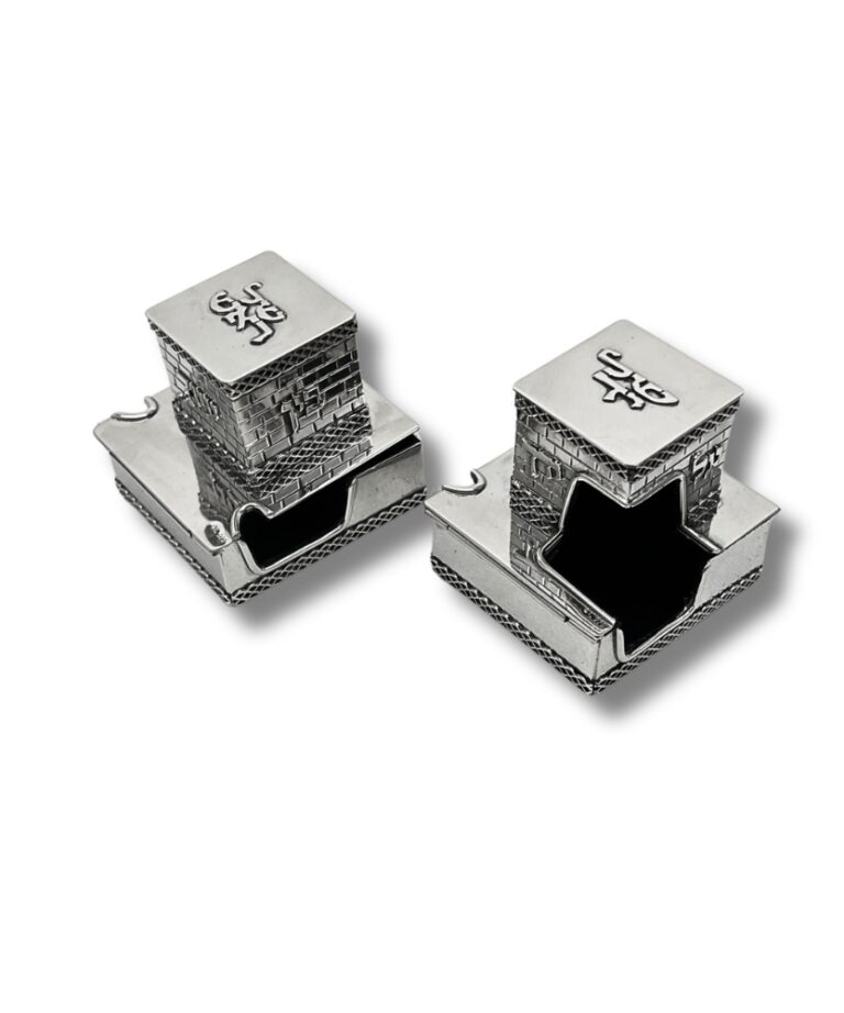 Angled view of two sterling silver tefillin boxes with detailed openings shaped for the tefillin placement
