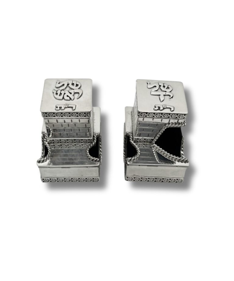 Front view of tefillin boxes partially opened with silver chains, displaying engraved Kotel-style walls and rounded entry design