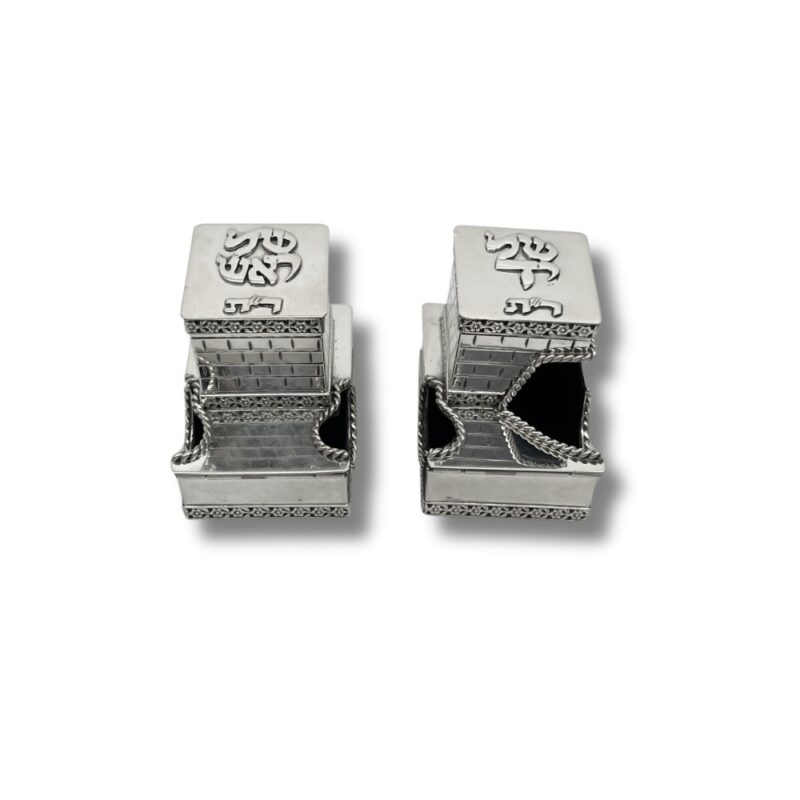 Front view of tefillin boxes partially opened with silver chains, displaying engraved Kotel-style walls and rounded entry design